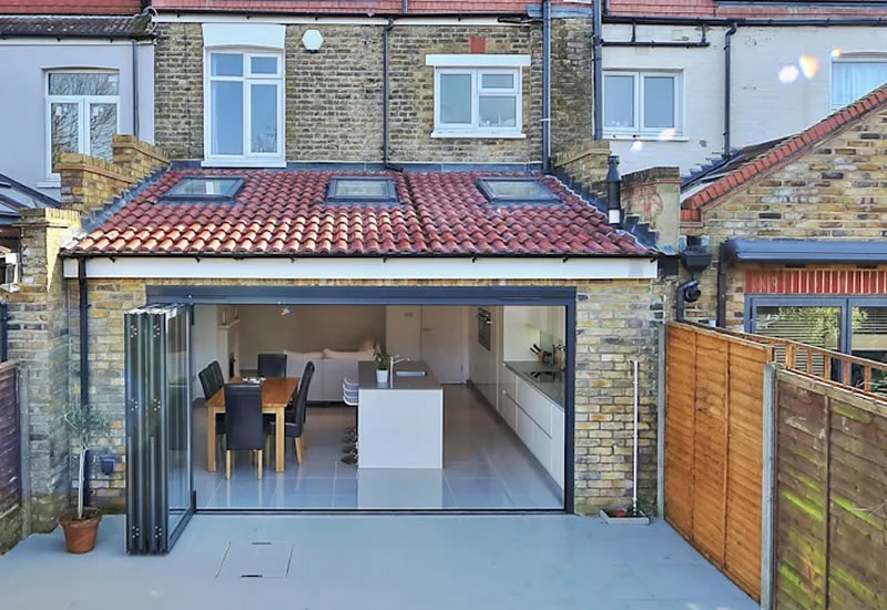 London-brick rear extension with bi-fold doors open to a kitchen-diner